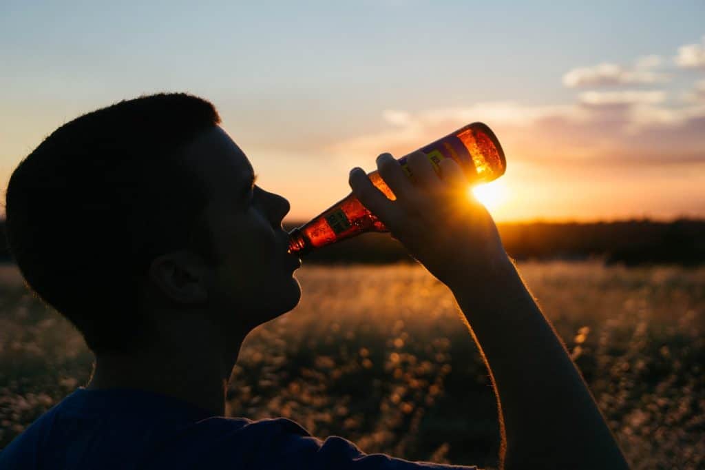 Man drinking alcohol in the field