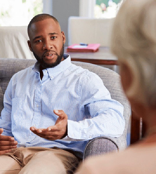 Man and therapist at a medication assisted treatment center discussing treatment options