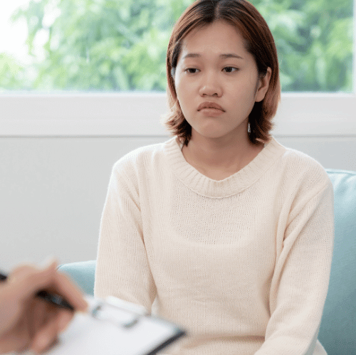 Young woman thinking quietly as a Partial hospitalization therapist takes notes