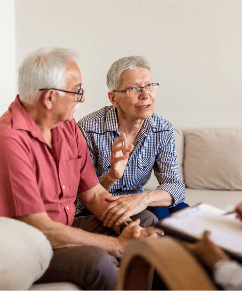 Senior couple talk to a therapist about the cost of medication-assisted treatment for addiction recovery