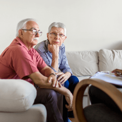 Senior couple discussing the cost of rehab with a therapist