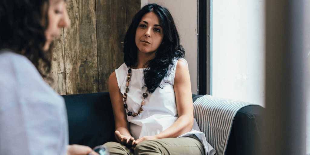 An LGBTQA woman listens as her therapist discusses mental health and substance addiction treament