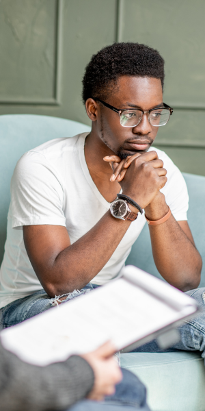 Young man thinking during a discussion about NYSHIP addiction counseling coverage