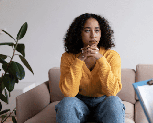 A young woman listens as a therapist explains outpatient mental health facility programs