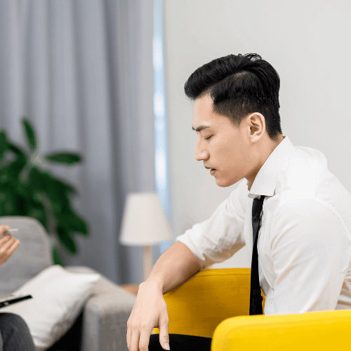 A young man closes his eyes during an assessment with a therapist for six-month addiction rehab options